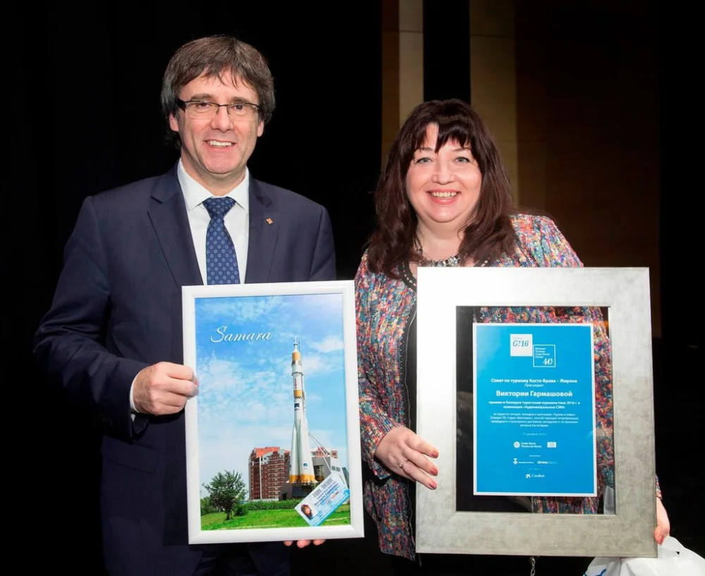 Victoria Garmashova holding the Premis G diploma beside Carles Puigdemont